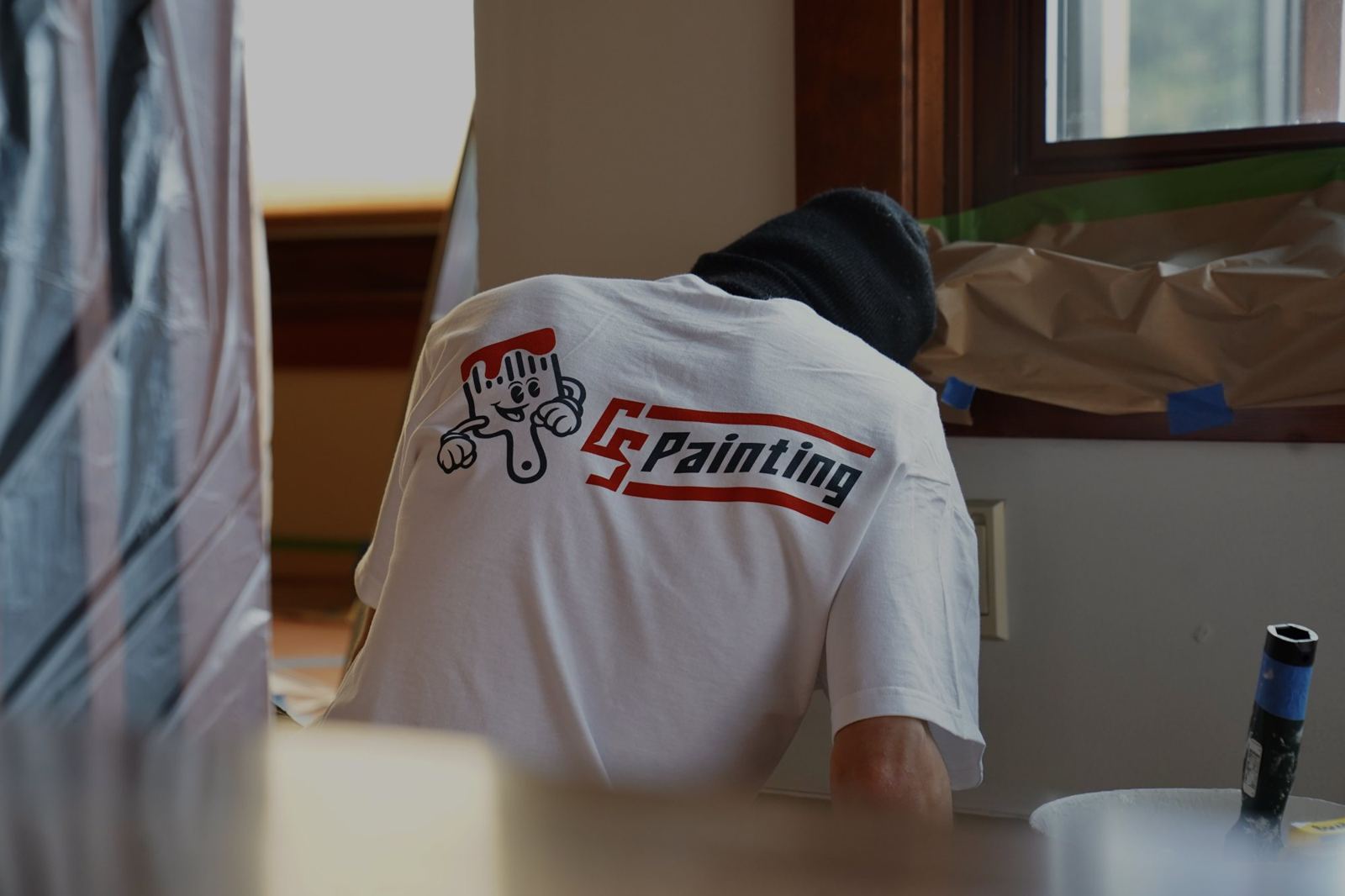 A CS Painting crew member working on a masked and protected kitchen