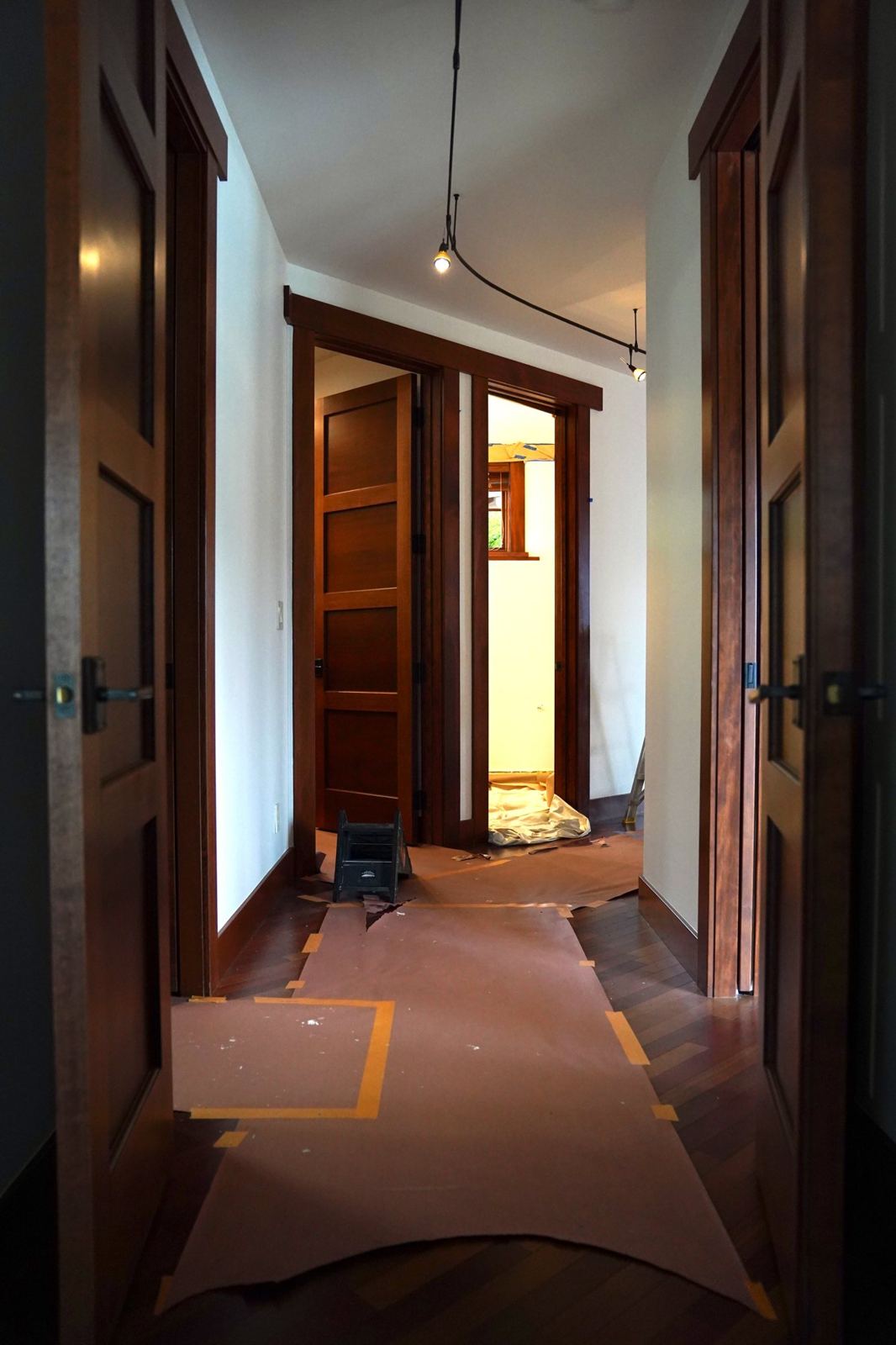 A hallway floor covered and taped before painting