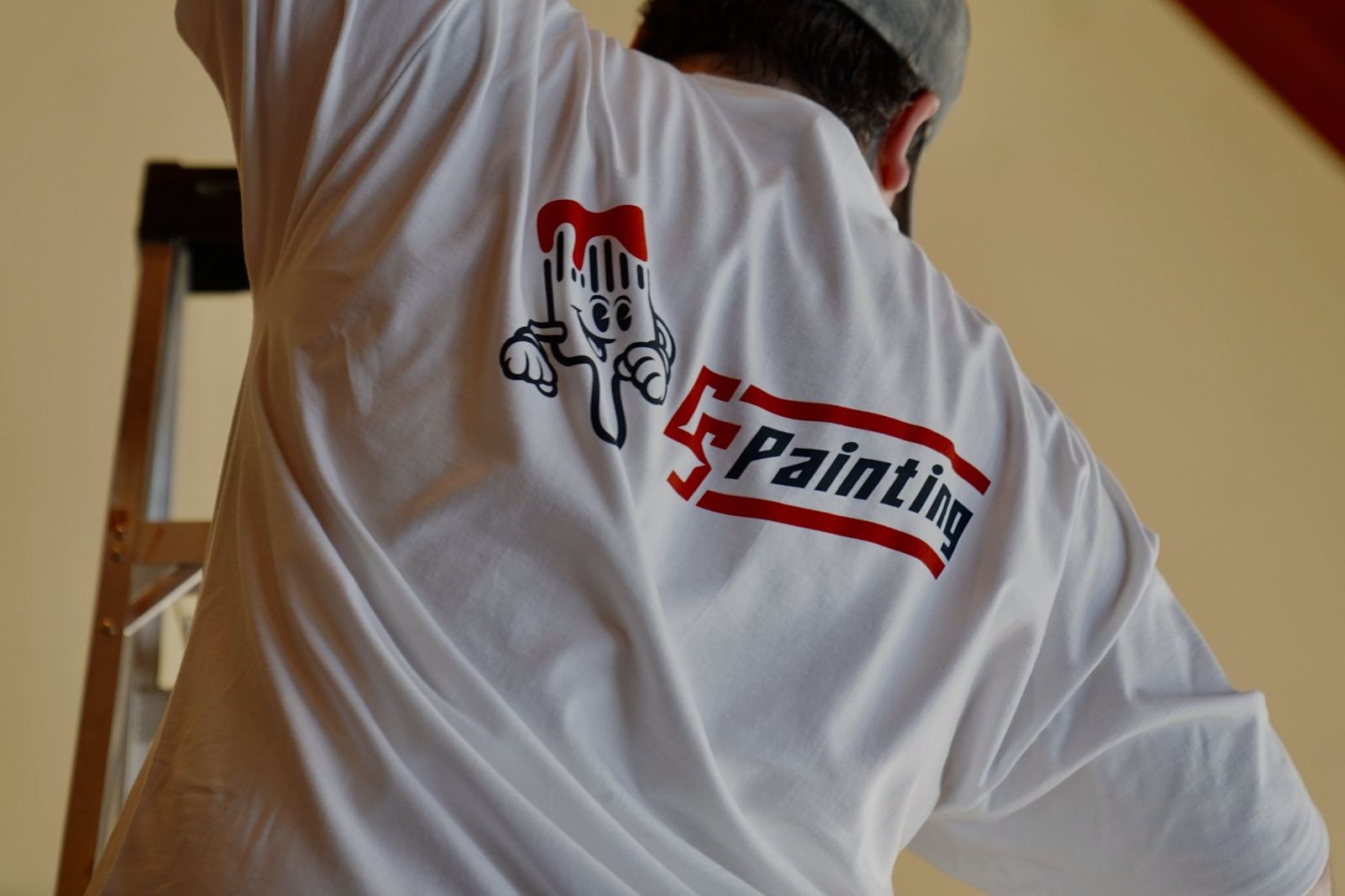 The CS Painting logo on the back of a crew shirt, on the job